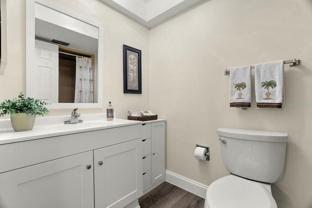 bathroom featuring hardwood / wood-style flooring, vanity, and toilet