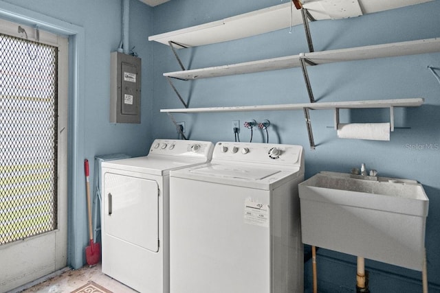 clothes washing area with electric panel, separate washer and dryer, and sink