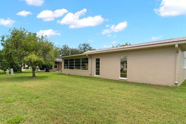 back of house featuring a lawn