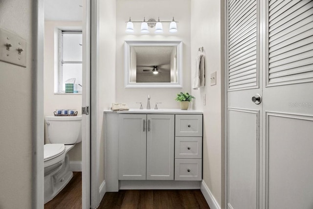 bathroom with hardwood / wood-style flooring, vanity, and toilet