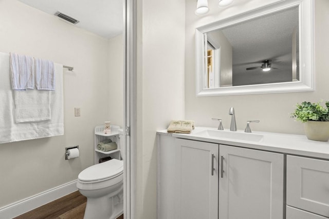 bathroom featuring vanity, ceiling fan, wood-type flooring, and toilet