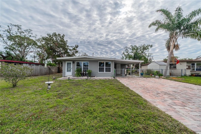 single story home featuring a front lawn and a carport