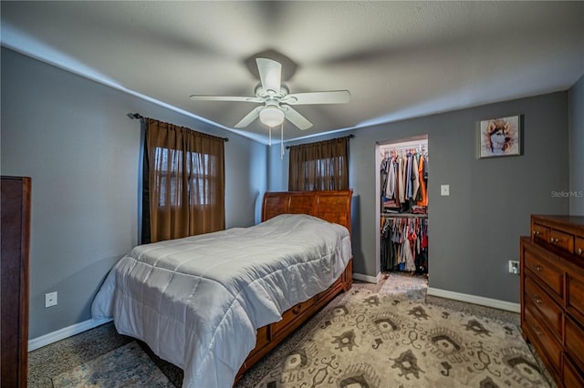 bedroom featuring a closet, a walk in closet, and ceiling fan