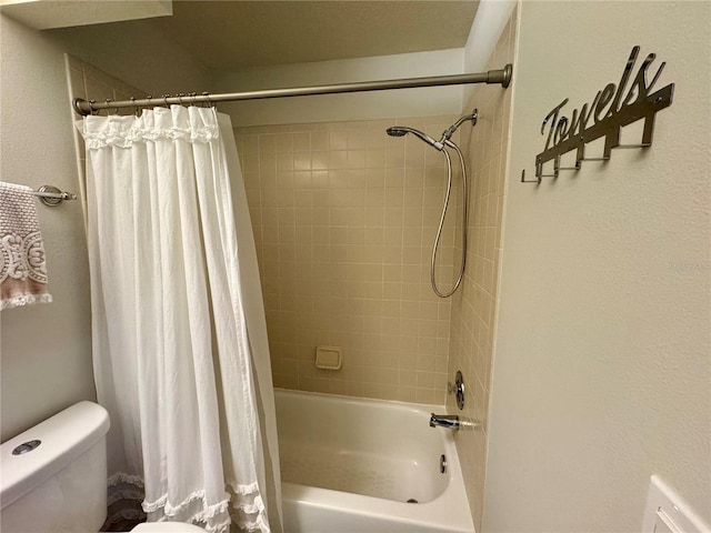 bathroom featuring toilet and shower / bath combination with curtain