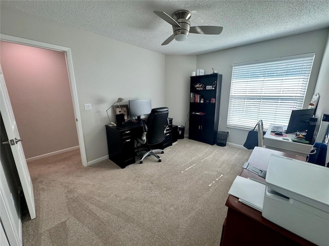 carpeted home office featuring ceiling fan and a textured ceiling