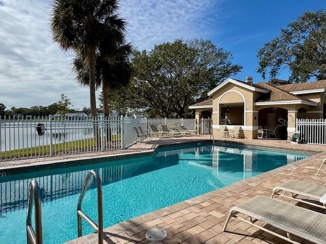 view of pool featuring a patio area and a water view