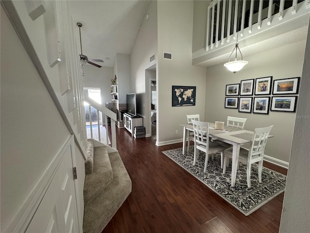 dining space with high vaulted ceiling, ceiling fan, and dark hardwood / wood-style floors