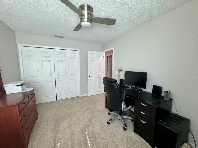 carpeted office with ceiling fan and a textured ceiling