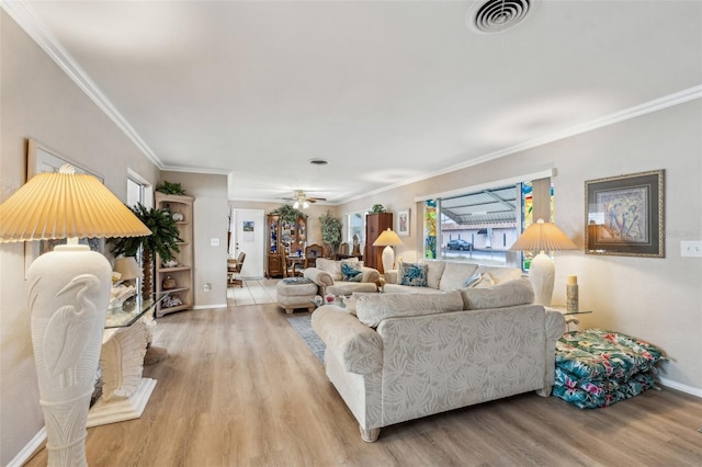 living room with light wood-type flooring, ceiling fan, and crown molding