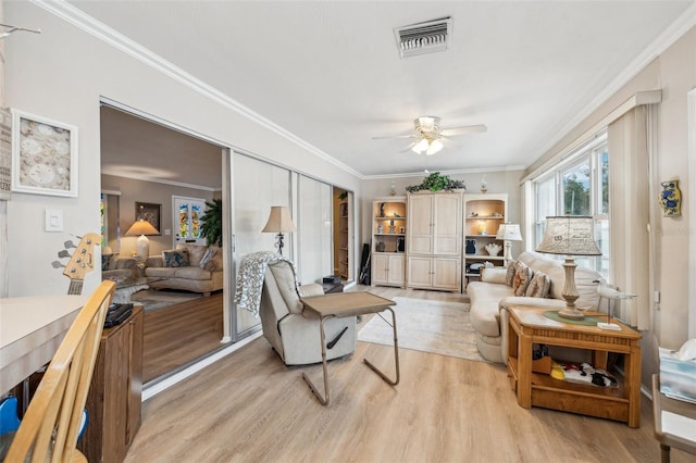 living room featuring ceiling fan, light hardwood / wood-style flooring, and crown molding