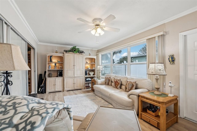 living room featuring ornamental molding, ceiling fan, and light wood-type flooring