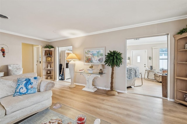 living room with ornamental molding and light hardwood / wood-style floors