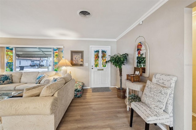 living room with light wood-type flooring, a wealth of natural light, and crown molding