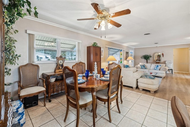 tiled dining area featuring ornamental molding and ceiling fan