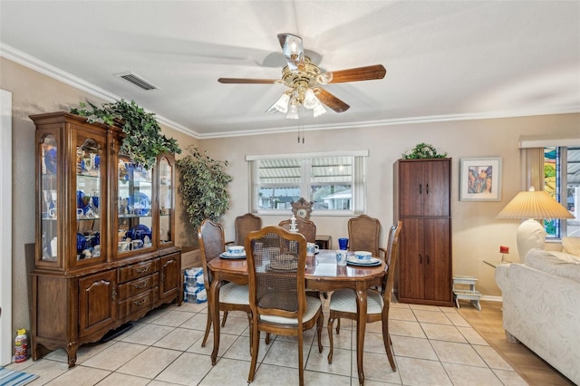 tiled dining room with ceiling fan, crown molding, and a wealth of natural light