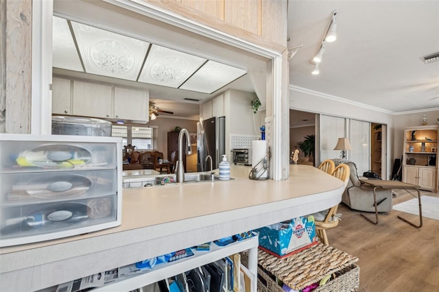 kitchen featuring stainless steel fridge with ice dispenser, ornamental molding, ceiling fan, sink, and light hardwood / wood-style flooring