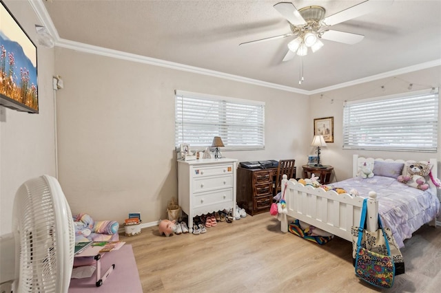 bedroom featuring ceiling fan, multiple windows, light hardwood / wood-style floors, and crown molding