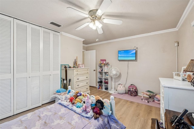 bedroom featuring a closet, ceiling fan, crown molding, and light hardwood / wood-style flooring