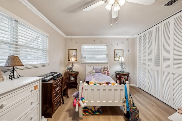 bedroom with ceiling fan, light hardwood / wood-style floors, ornamental molding, and a closet