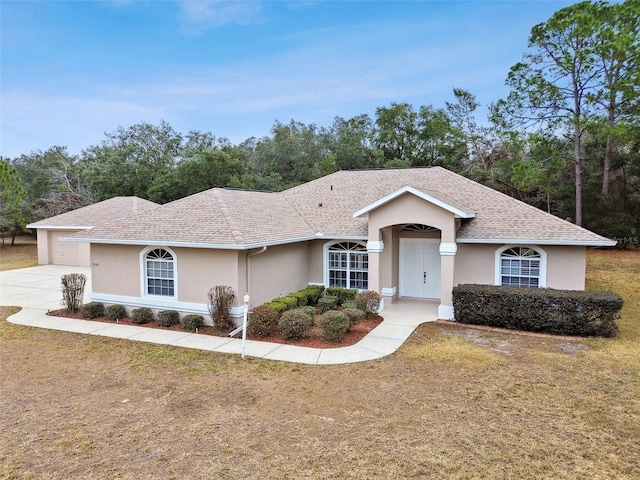 single story home featuring a garage and a front yard