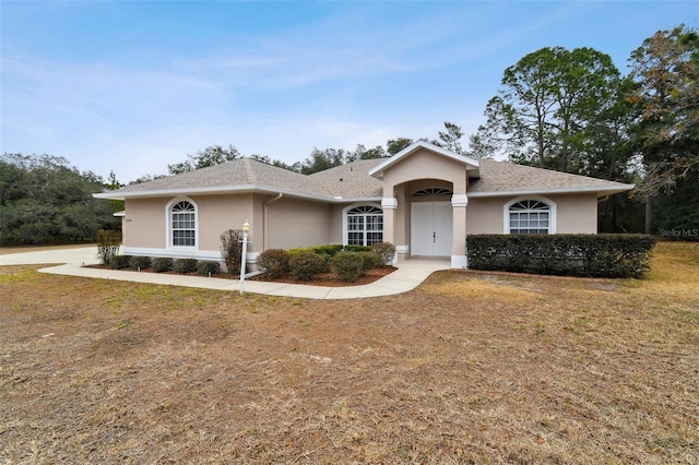 single story home featuring a front lawn