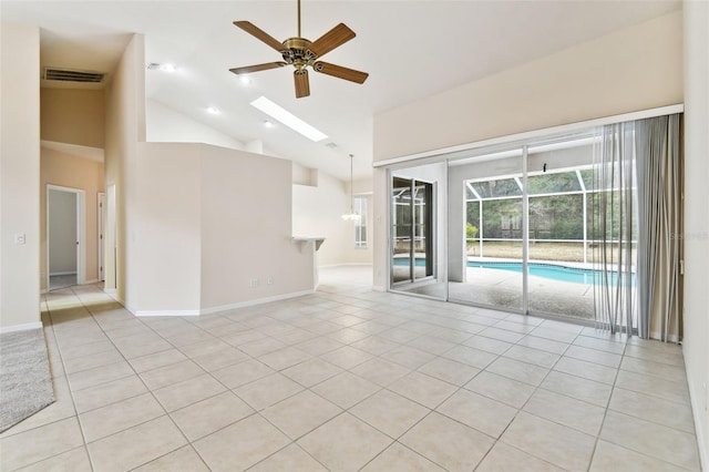 tiled empty room with ceiling fan and high vaulted ceiling