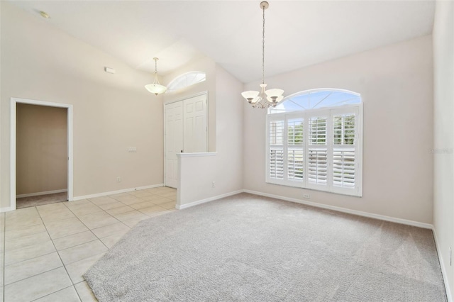 tiled spare room with a chandelier and vaulted ceiling