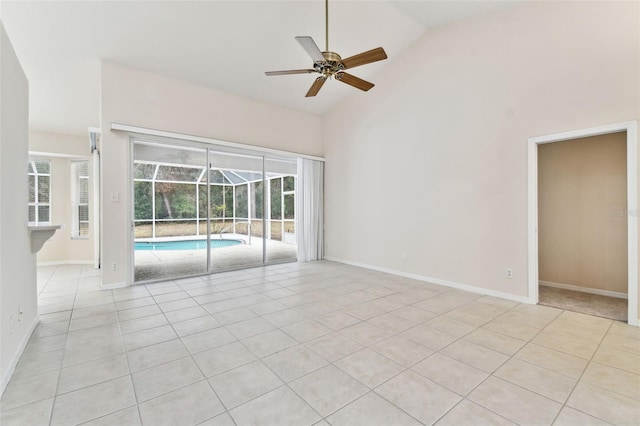 unfurnished room with ceiling fan, high vaulted ceiling, and light tile patterned flooring