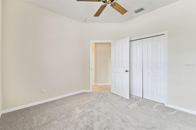 unfurnished bedroom with ceiling fan, a closet, and light carpet