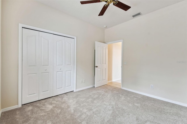 unfurnished bedroom with ceiling fan, a closet, and light colored carpet