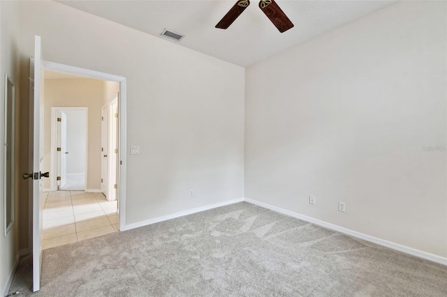 empty room featuring ceiling fan and light colored carpet