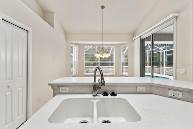 kitchen with decorative light fixtures, sink, a wealth of natural light, and a chandelier