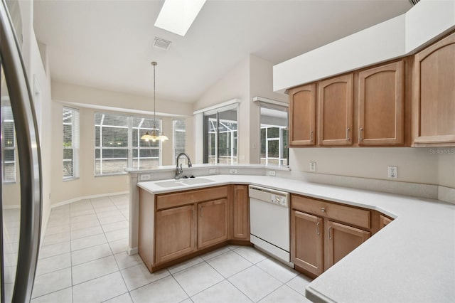 kitchen with dishwasher, pendant lighting, light tile patterned flooring, sink, and stainless steel fridge