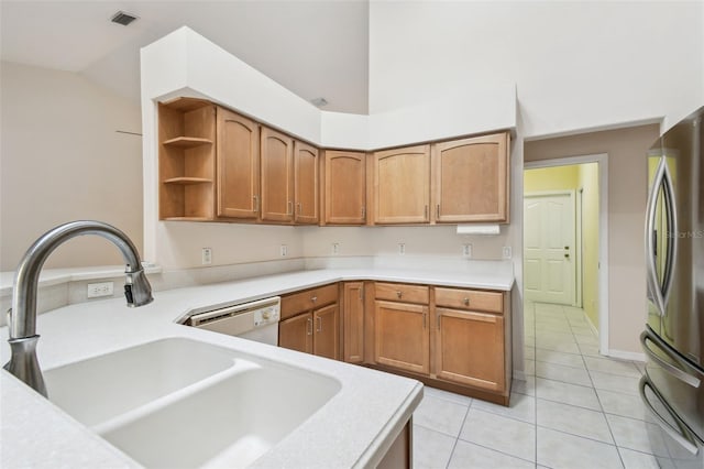 kitchen featuring light tile patterned flooring, sink, stainless steel fridge, vaulted ceiling, and white dishwasher