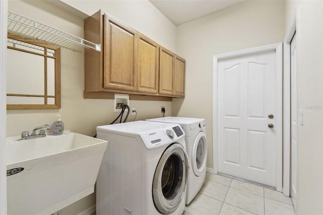 laundry area featuring cabinets, sink, washing machine and dryer, and light tile patterned flooring