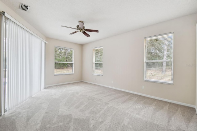 carpeted spare room featuring ceiling fan