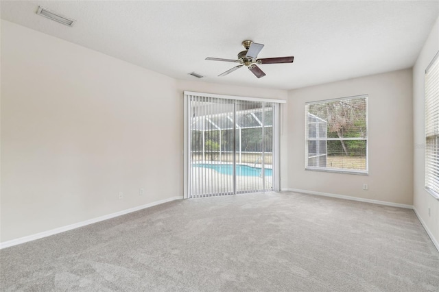 carpeted spare room with ceiling fan