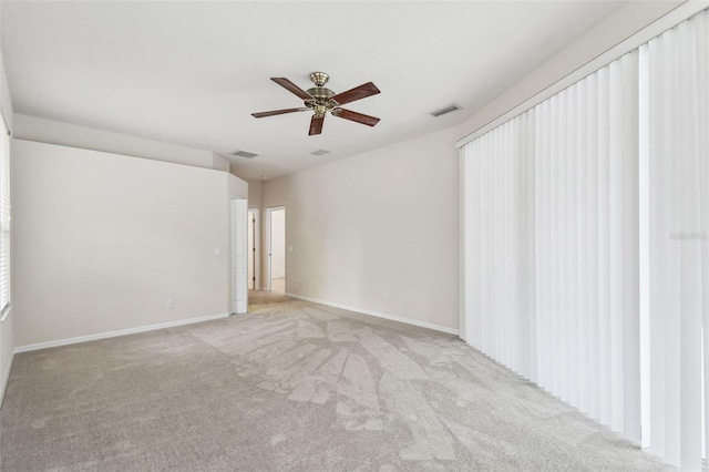 carpeted spare room featuring ceiling fan