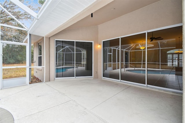 view of patio with glass enclosure and ceiling fan