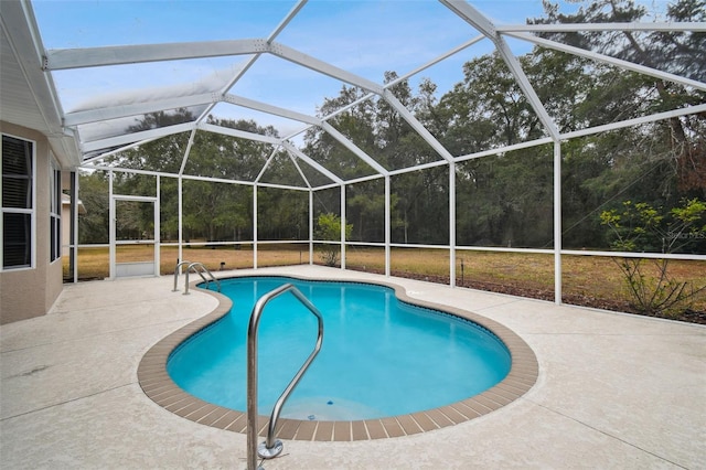 view of pool featuring glass enclosure and a patio area