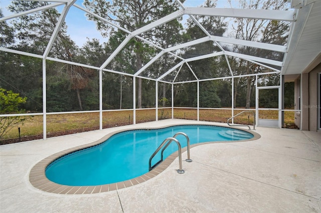 view of swimming pool with glass enclosure and a patio area