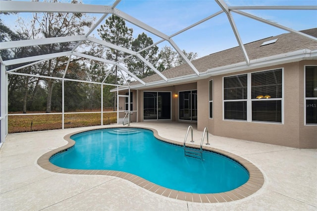 view of pool featuring glass enclosure and a patio