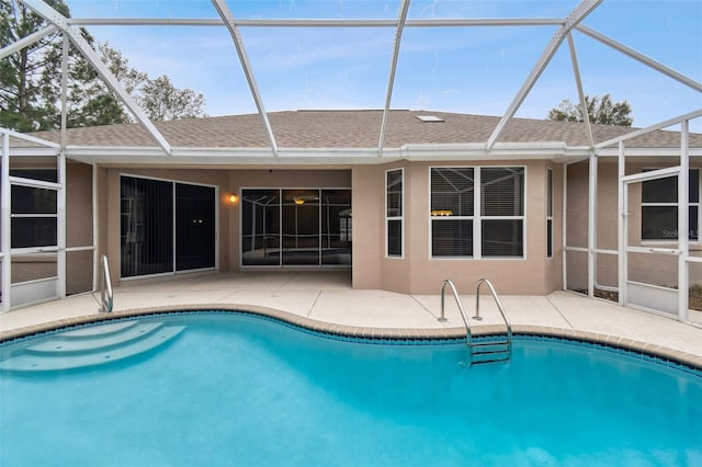 view of swimming pool featuring glass enclosure and a patio