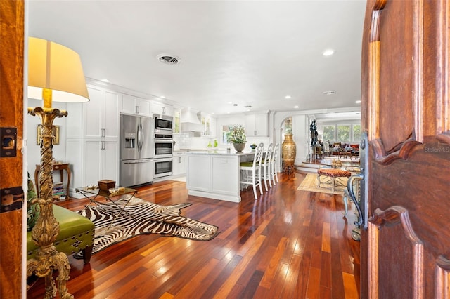 living area with visible vents, dark wood-style flooring, and recessed lighting