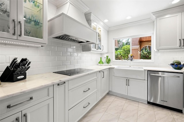 kitchen featuring white cabinets, glass insert cabinets, stainless steel dishwasher, premium range hood, and a sink