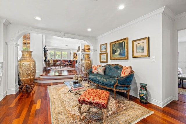 living room featuring arched walkways, crown molding, dark wood finished floors, and ornate columns