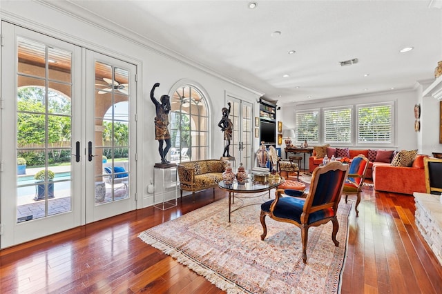 living area with french doors, ornamental molding, wood finished floors, and recessed lighting