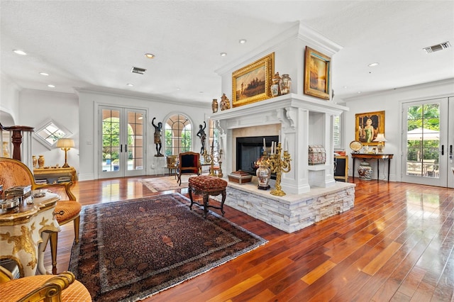 living room featuring french doors, plenty of natural light, and visible vents