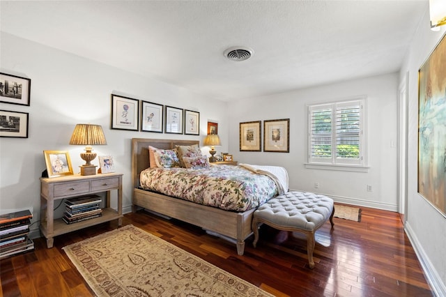 bedroom with visible vents, dark wood finished floors, and baseboards