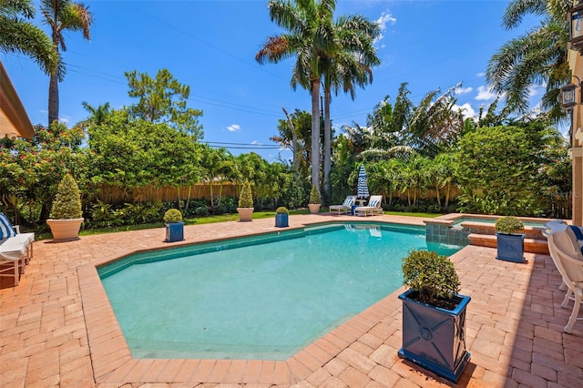 view of swimming pool with a patio area, a fenced backyard, and a pool with connected hot tub